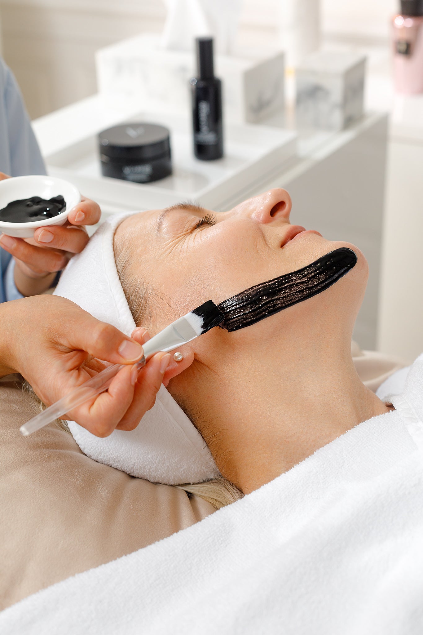 CP Praxis Kundin wird mit Carbon Peeling Maske während der Kosmetikbehandlung verwöhnt